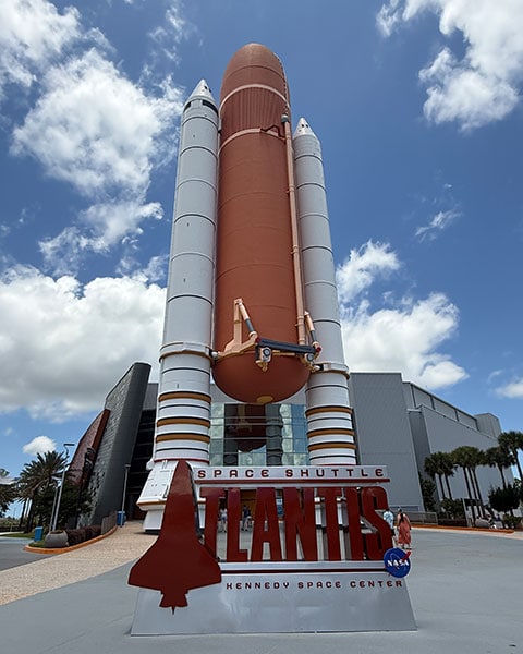 Ein riesiger, originalgetreuer Nachbau des orangefarbenen Außentanks und der beiden weißen Feststoffraketen am Eingang der „Space Shuttle Atlantis“-Ausstellung im Kennedy Space Center.