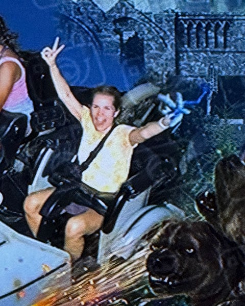 Eine Frau streckt während der Fahrt in der Achterbahn „Hagrid’s Magical Creatures Motorbike Adventure“ die Arme in die Luft.